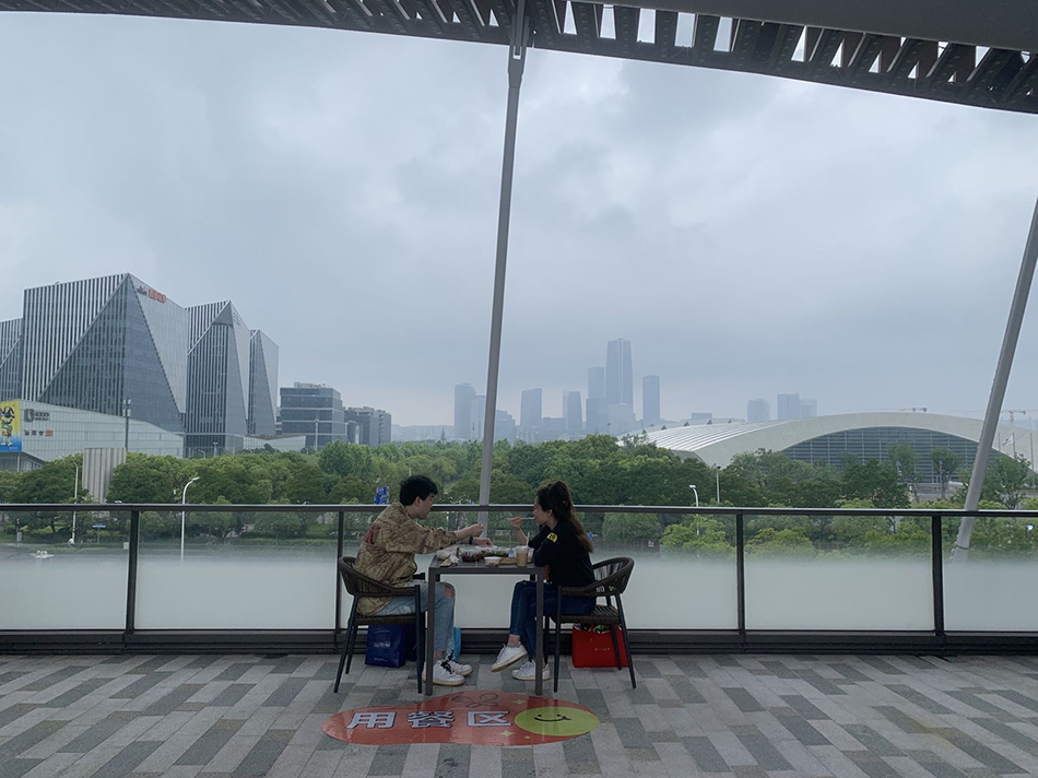 情侣在室外就餐点享受雨中美食