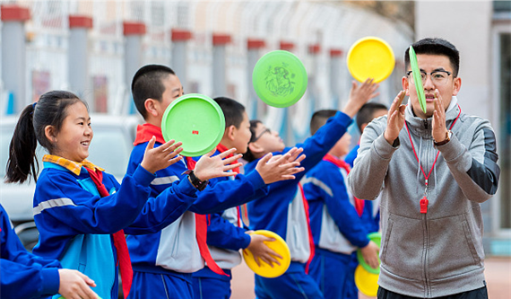 2021年3月，呼和浩特市玉泉区民族实验小学学生在教练的指导下练习飞盘。图片来自CFP