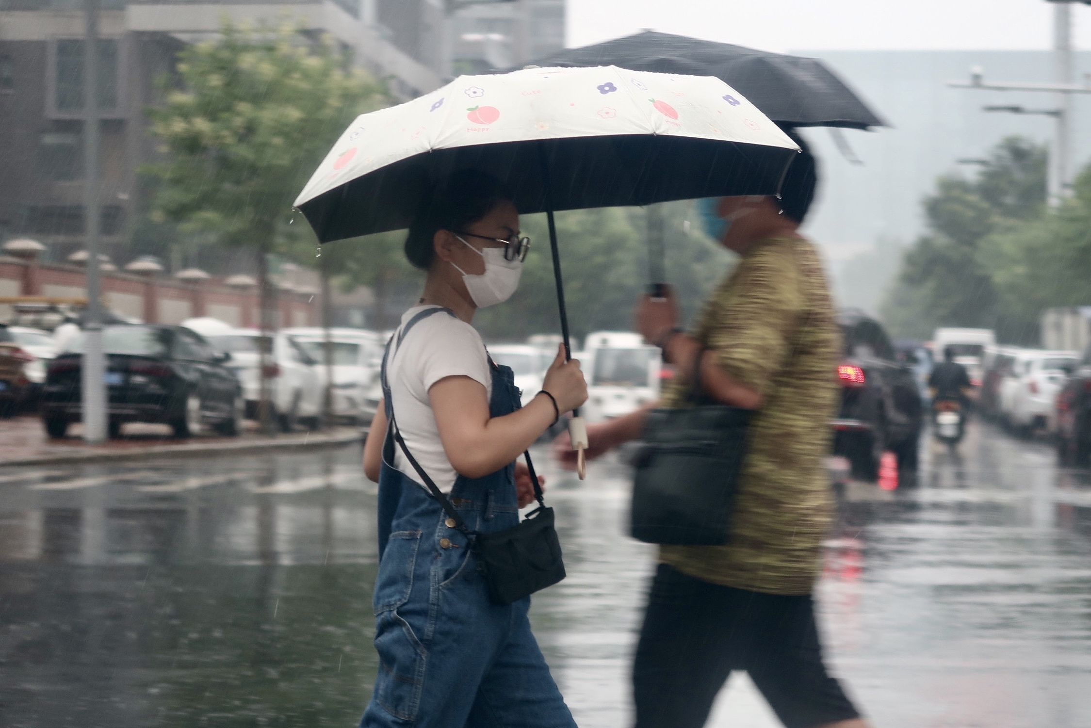 2022年7月22日，郑州市民雨中出行。