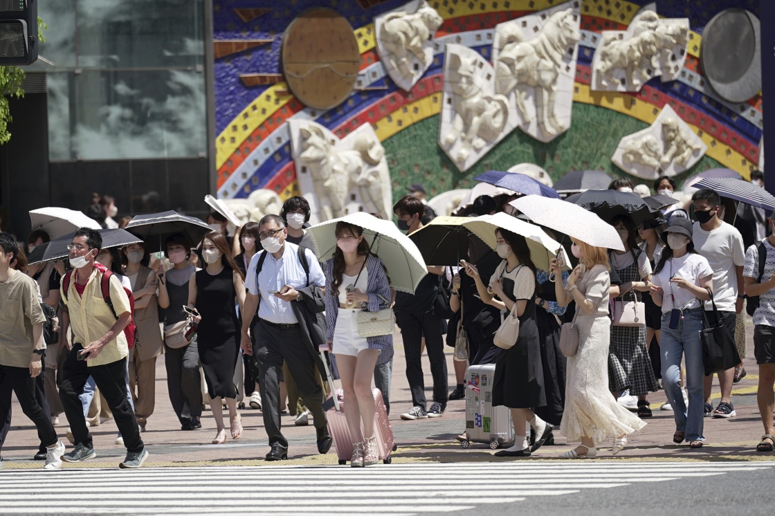 7月25日，人们戴口罩在日本东京街头行走。新华社 图