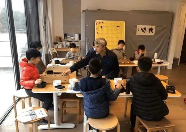 江铸久在指导孩子们下棋