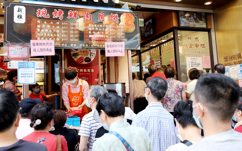 消费者在上海南京东路上的新雅食品公司外卖柜台前排队购买月饼   新华社图